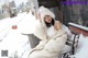 A woman sitting on a bench in the snow.