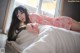 A woman in a pink kimono laying on a bed.