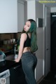 A woman standing in a kitchen next to a washing machine.