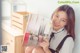 A woman sitting on a chair holding a magazine.