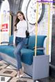 A woman standing next to a blue couch in a subway station.