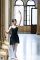 A young ballerina in a black leotard and pointe shoes.