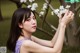 A woman in a purple dress holding a white flower.