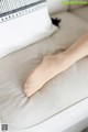 A woman's bare foot resting on a white couch.