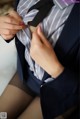 A woman in a suit adjusting her tie. 