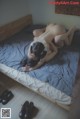 A naked woman laying on a bed next to a pair of shoes.