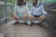 Two young women in school uniforms sitting on a bench.