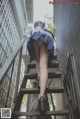 A woman in a school uniform is walking up some stairs.