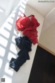 A red and black bra sitting on top of a white bench.