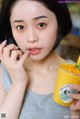 A woman holding a glass of orange juice with a straw.