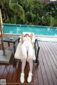 A woman laying on a lounge chair next to a swimming pool.