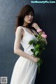 A woman in a white dress holding a bouquet of flowers.