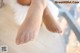 A close up of a woman's bare feet on a wooden floor.