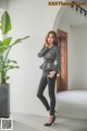 A woman standing next to a plant in a room.