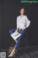 A woman sitting on a chair holding a book.