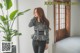 a woman standing next to a potted plant in a room