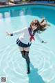 A woman in a school uniform is standing in a pool.