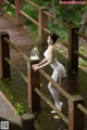 A woman in a white dress standing on a wooden bridge.