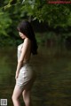 A woman in a silver dress standing in the water.