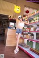 A woman standing in front of a store holding a yellow balloon.