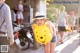 A woman in a straw hat holding a Winnie the Pooh balloon.