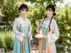 A couple of women standing next to each other in a garden.