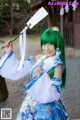 A woman in a blue and white dress holding a sword.