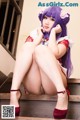 A woman with purple hair is sitting on the stairs.