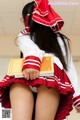 A woman in a red and white uniform holding a book.