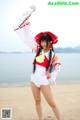 A woman in a red and white outfit holding a sword.