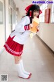 A woman in a school uniform holding a book.