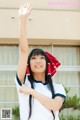 A woman in a white shirt and a red bandana waving her hand.