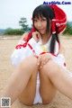 A woman in a red and white outfit sitting on the ground.