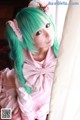 A woman with green hair wearing a pink dress.