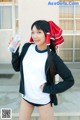 A woman in a santa hat holding a water bottle.