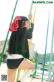 A woman in a black shirt and white shorts on a playground.