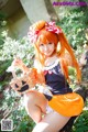 A woman with long orange hair sitting on a rock holding a basket.