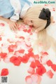 A woman laying on the floor covered in rose petals.