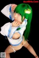 A woman with green hair wearing a white and blue outfit.