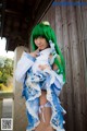 A woman with green hair wearing a blue and white dress.