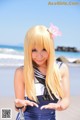 A woman in a sailor outfit on the beach.