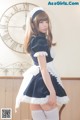 A woman in a maid outfit posing for a picture.