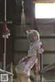 A woman dressed as a nurse with blood on her body.