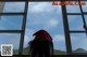 A woman with a red hat looking out of a window.