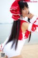 A woman in a red and white outfit on the beach.