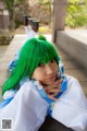 A woman with green hair laying on a wooden deck.