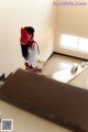 A woman in a school uniform standing in a hallway.