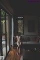 A naked woman sitting on a couch in a living room.