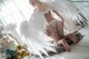 A woman in a white angel costume sitting on the floor.