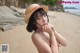 A woman in a straw hat on a beach.